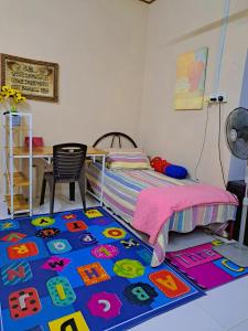 una camera con un letto e un tappeto colorato di Homestay Machang - Lycaste Inn Muslim a Macang