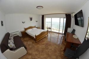 a bedroom with a bed and a view of the ocean at ADONIS Costinesti in Costinesti