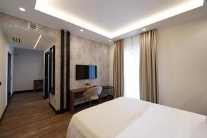 una camera con letto, scrivania e TV di Re Di Cuori Hotel a Caianello