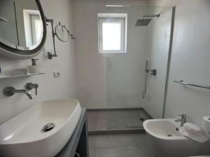 een witte badkamer met een wastafel en een douche bij La Pica Marina Anacapri in Anacapri