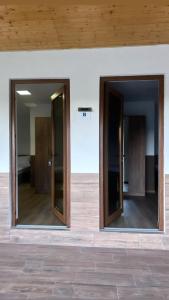 zwei Glastüren an der Seite eines Gebäudes in der Unterkunft Popas Momaia in Curtea de Argeş