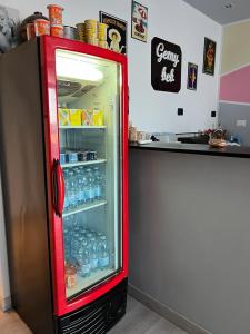 un frigorifero rosso riempito con bottiglie d'acqua accanto a un bancone di Gemy a Boissano