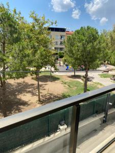a balcony with a view of a park at Bornova nezih ferah Yıllık-Aylık_Haftalık in Burunabat