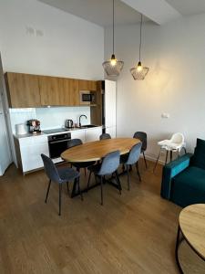 a living room with a table and chairs and a kitchen at Apartments Deluxe SARBINOWO in Sarbinowo