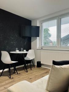 a dining room with a table and white chairs at Apartamenty Modrzewiowa Zator in Piotrowice