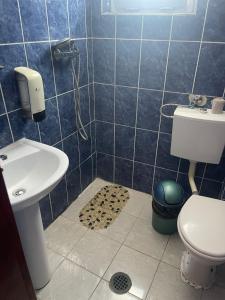 a blue tiled bathroom with a toilet and a sink at Hotel Capu' Turcului in Eforie Sud