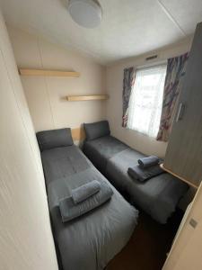 a small room with two beds and a window at Fantasy Island, Sunnymede 8 Berth in Ingoldmells