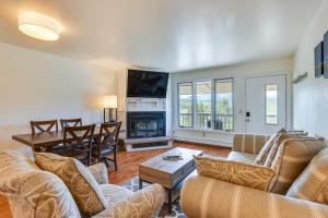 ein Wohnzimmer mit einer Couch, einem Tisch und einem Kamin in der Unterkunft Fraser Condo Rental with Balcony, Mountain Views! in Fraser