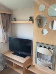 a living room with a television and a fireplace at Fantasy Island, Sunnymede 8 Berth in Ingoldmells