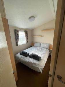 a small bedroom with a white bed in a room at Fantasy Island, Sunnymede 8 Berth in Ingoldmells