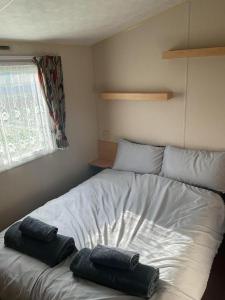 a bed in a room with two pillows on it at Fantasy Island, Sunnymede 8 Berth in Ingoldmells