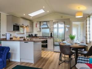 a large kitchen with a table and a dining room at Buttercup in Swadlincote