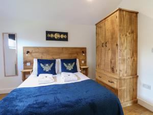 a bedroom with a blue bed with two towels at Birch in Swadlincote