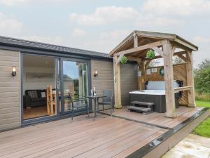 a deck with a hot tub and a pergola at Oak in Swadlincote