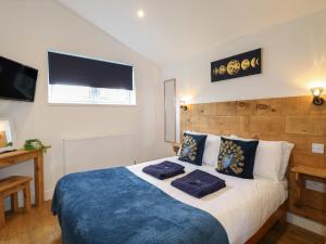 a bedroom with a bed with two blue pillows on it at Juniper in Swadlincote