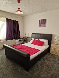 una camera da letto con un letto grande con una coperta rossa di Chimes-Company & Family Stay, 2 Bedroom House + Free parking a Tamworth