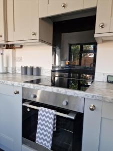 a kitchen with an oven with a towel hanging from it at Chimes-Company & Family Stay, 2 Bedroom House + Free parking in Tamworth