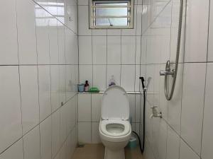 a white bathroom with a toilet and a window at Padang Besar Homestay Firdaus in Padang Besar