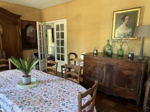 uma sala de jantar com uma mesa e um quadro na parede em La Petite Trolière em Orval