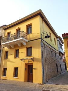 un bâtiment jaune avec un balcon dans une rue dans l'établissement To Agioklima, à Ioannina