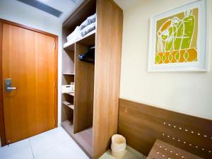 ein Schrank mit einer Holztür und einem Gemälde an der Wand in der Unterkunft Hotel Rainha do Brasil in Aparecida