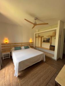 1 dormitorio con 1 cama blanca grande con almohadas azules en Balear Hotel en Ciutadella