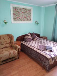 RomnyにあるГотель Стефаніяの小さなベッドルーム(ベッド1台、椅子付)
