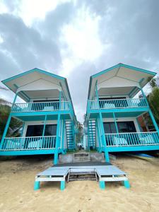 two large blue houses on the beach with benches at Pondok Beach Shack in Tioman Island