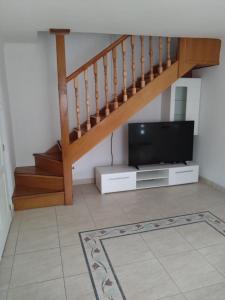 sala de estar con TV y escalera en Tókert Apartman, en Ráckeve