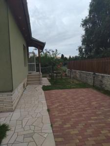 eine Terrasse eines Hauses mit einem Zaun in der Unterkunft Tókert Apartman in Ráckeve