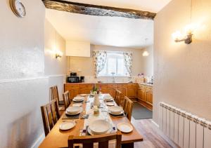 a dining room with a long table in a kitchen at Courtney - Upcott House in Barnstaple