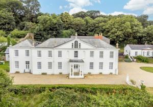 an exterior view of a large white house at Courtney - Upcott House in Barnstaple