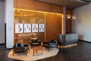 a lobby with chairs and a table and pictures on the wall at The WB Abu Dhabi, Curio Collection By Hilton in Abu Dhabi