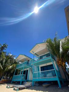 a blue house on the beach with palm trees at Pondok Beach Shack in Tioman Island