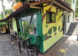 a small house with a green and yellow at Romeo y Julieta, cabaña privada en Minca in Minca