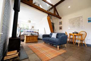 a living room with a blue couch and a stove at Worfe View Cottage in Ryton