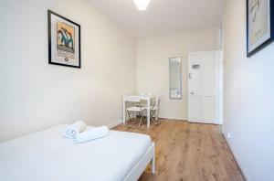 ロンドンにあるAPlaceToStay Central London Apartment, Zone 1 COVの白いベッドとテーブルのある白い寝室
