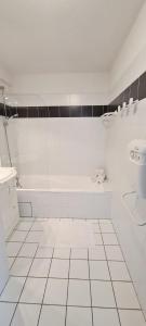 La salle de bains blanche est pourvue d'une baignoire et d'un lavabo. dans l'établissement Résidence Goélia Les Gorges de la Truyère, à Entraygues-sur-Truyère