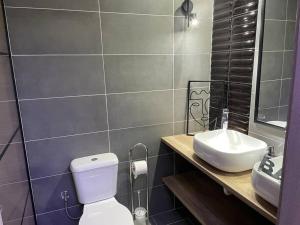 a bathroom with a white toilet and a sink at Ladadika Family Apartment in Thessaloniki
