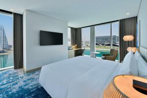 a hotel room with a large bed and a tv at Hilton Garden Inn Bahrain Bay in Manama