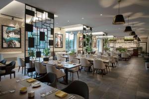 a restaurant with tables and chairs in a room at Hilton Beirut Downtown in Beirut