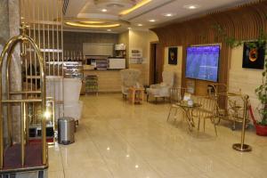 a lobby with a waiting area with chairs and tables at Al Bateel Furnished Apartments in Riyadh
