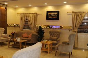 a waiting room with couches and chairs and a table at Al Bateel Furnished Apartments in Riyadh