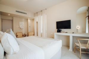 a white bedroom with a large bed and a desk at Thymises Boutique Hotel in Kakopetria