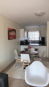 a kitchen and dining room with a table and chairs at Menlyn Place Staycation in Pretoria