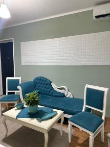 sala de estar con sofá azul y 2 sillas en Guest House Memo at the center of kutaisi, en Kutaisi