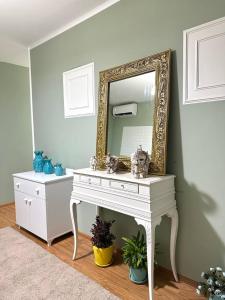 a white dressing table with a mirror on a wall at Guest House Memo at the center of kutaisi in Kutaisi