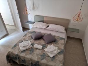 una camera da letto con un letto con cuscini sopra di Lapis rooms a Pachino
