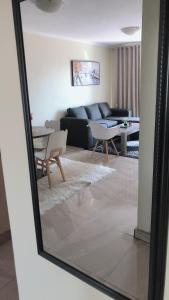 a mirror reflection of a living room with a couch at Menlyn Place Staycation in Pretoria