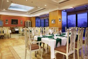 um salão de banquetes com mesas e cadeiras numa sala em Hilton Pyramids Golf em Cidade 6 de Outubro